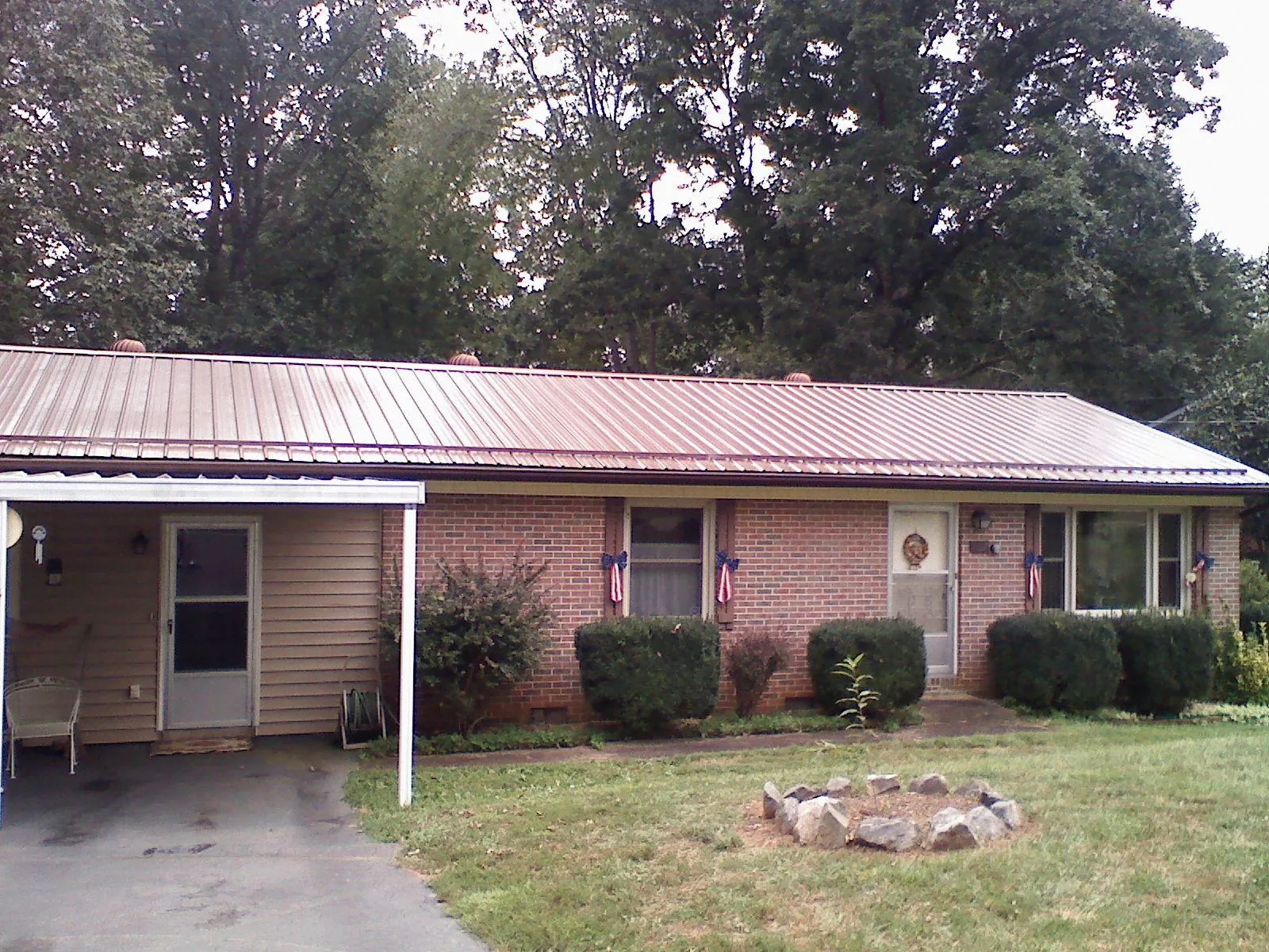 Bronze metal roof and carport on a brick ranch home — Roof Repair work by our crew in Hillburn